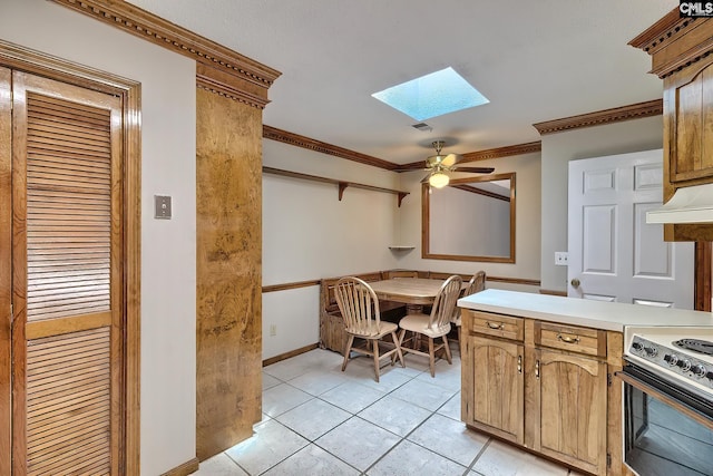 kitchen featuring crown molding, a skylight, light tile patterned floors, range with electric stovetop, and ceiling fan