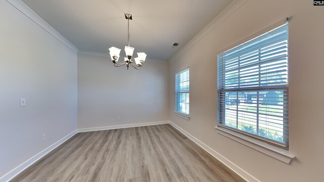 unfurnished room with hardwood / wood-style flooring, a chandelier, and ornamental molding