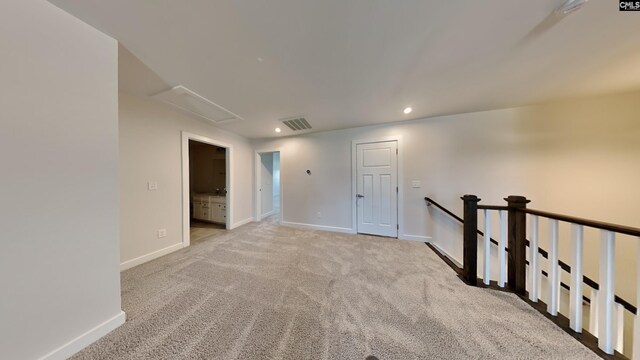 spare room featuring light carpet