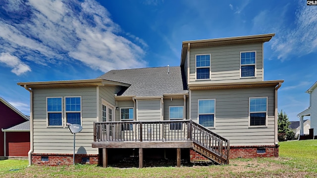 rear view of house featuring a wooden deck and a yard