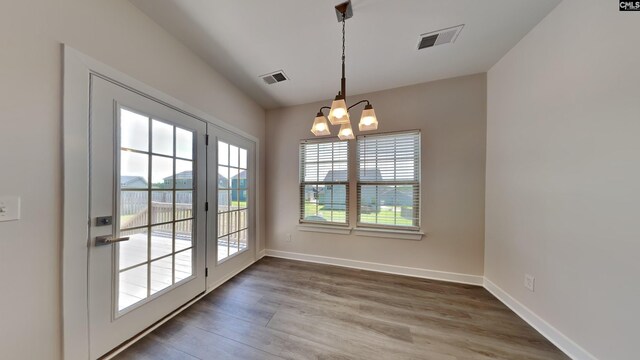 interior space featuring wood-type flooring and a notable chandelier