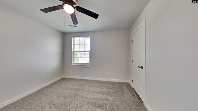 carpeted spare room with ceiling fan