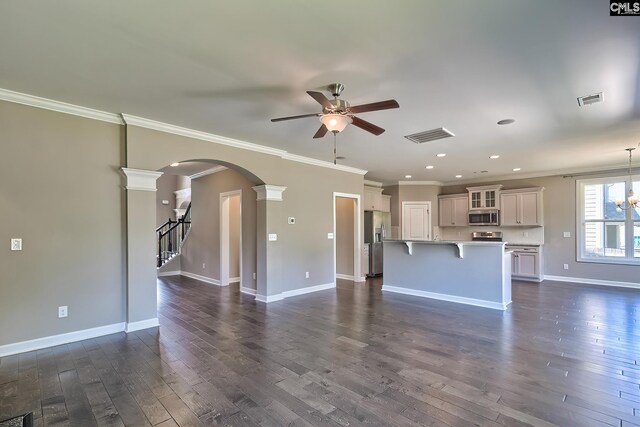 unfurnished living room featuring ornamental molding, ornate columns, dark hardwood / wood-style flooring, and ceiling fan