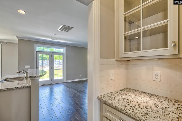 kitchen with crown molding, french doors, backsplash, wood-type flooring, and sink