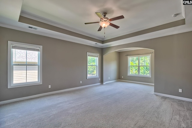 carpeted empty room with crown molding, ceiling fan, and a raised ceiling