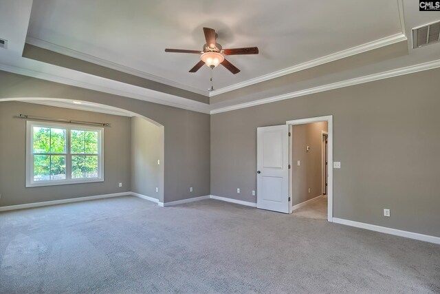 unfurnished room featuring crown molding, a raised ceiling, light colored carpet, and ceiling fan