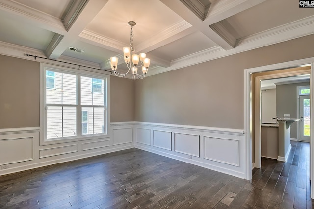 spare room featuring an inviting chandelier, dark wood-type flooring, a wealth of natural light, and coffered ceiling