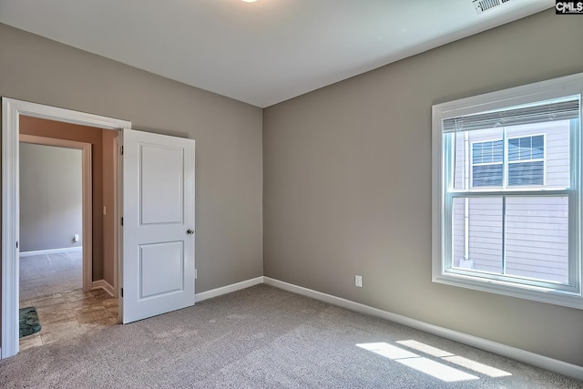 unfurnished bedroom with multiple windows and light carpet