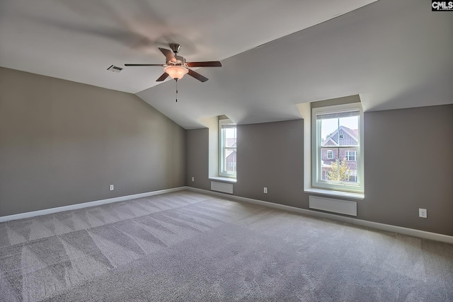 carpeted empty room with vaulted ceiling and ceiling fan