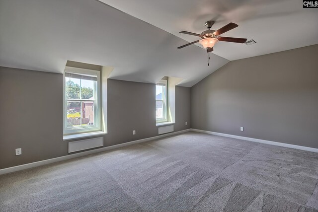 additional living space featuring vaulted ceiling, carpet, ceiling fan, and a healthy amount of sunlight