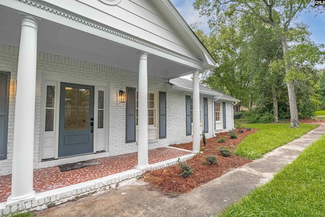 view of exterior entry featuring covered porch