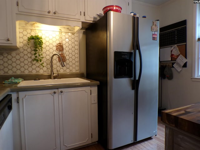 kitchen featuring white cabinetry, sink, backsplash, and stainless steel fridge