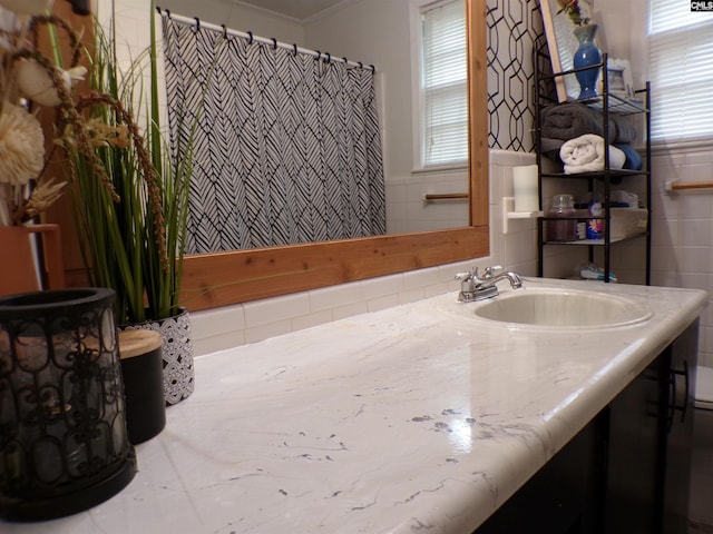 bathroom featuring a wealth of natural light, tile walls, and vanity