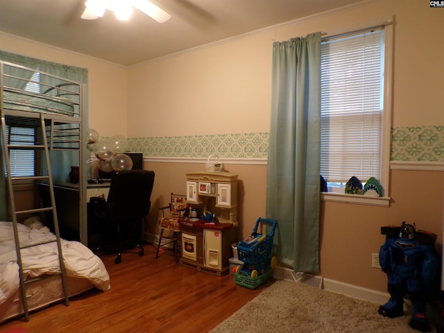 bedroom featuring hardwood / wood-style flooring, ceiling fan, and crown molding