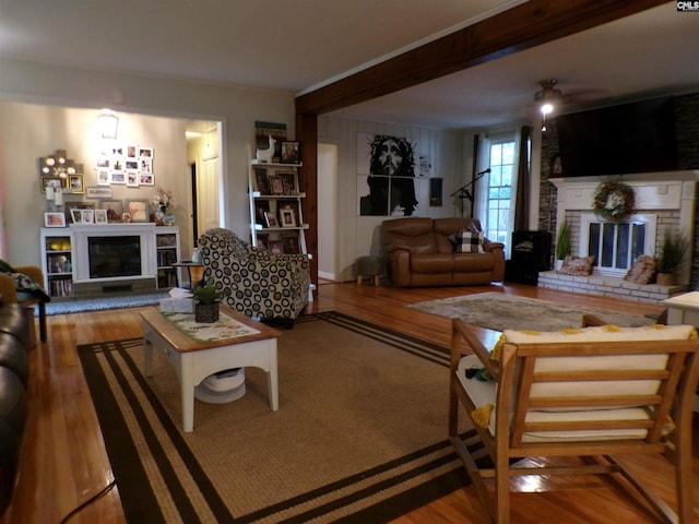 living room featuring a brick fireplace and hardwood / wood-style flooring