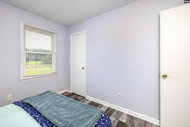 bedroom with dark hardwood / wood-style flooring