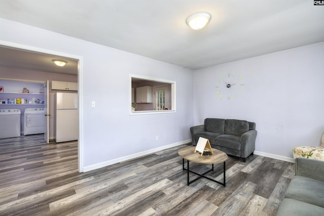 living room featuring washing machine and dryer and dark hardwood / wood-style flooring