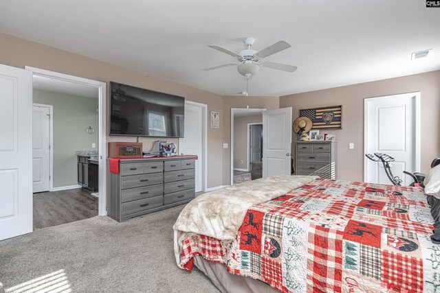 bedroom featuring ensuite bath, carpet floors, and ceiling fan