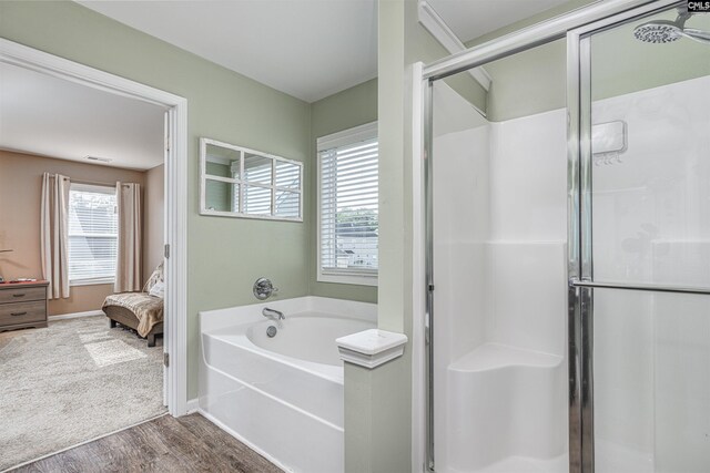 bathroom with hardwood / wood-style flooring, shower with separate bathtub, and plenty of natural light