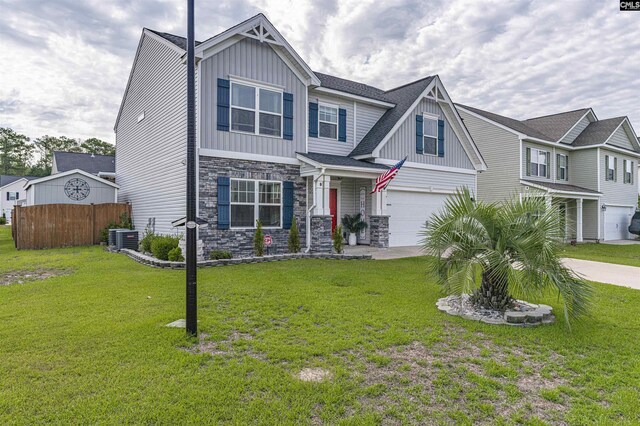 craftsman house with cooling unit, a garage, and a front yard