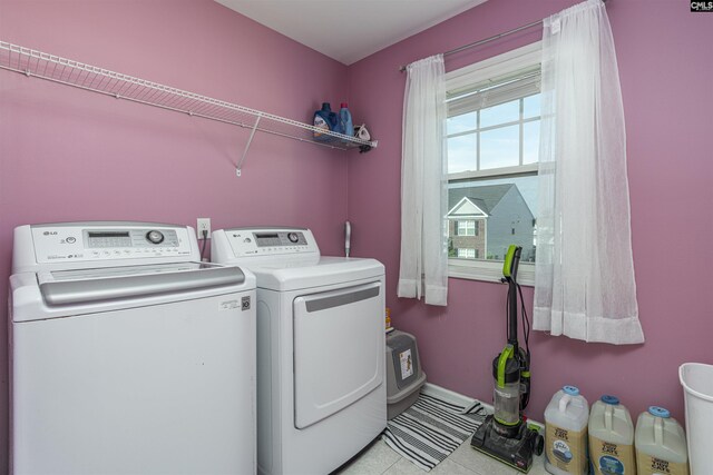 clothes washing area with light tile patterned flooring and independent washer and dryer