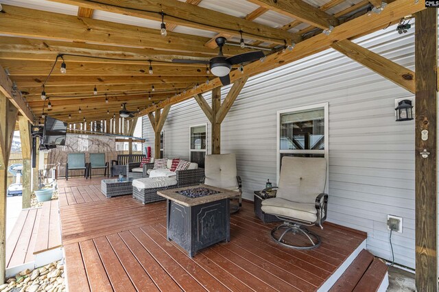 wooden deck with an outdoor living space with a fire pit and ceiling fan