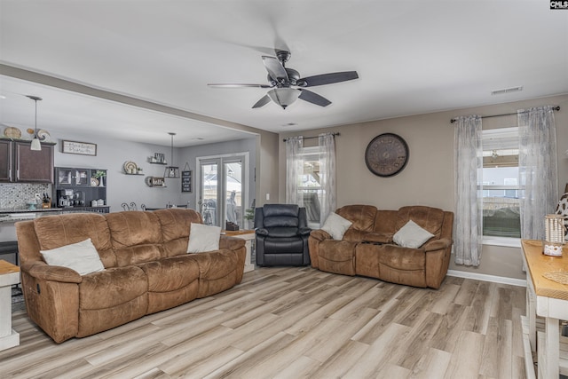 living room featuring light wood-type flooring and ceiling fan