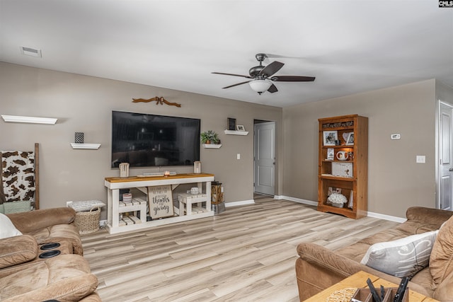 living room featuring light hardwood / wood-style flooring and ceiling fan