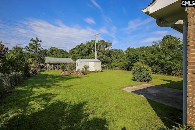 view of yard with a storage unit, fence, and an outdoor structure