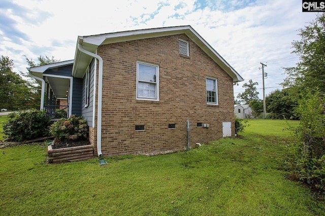 view of property exterior with crawl space, brick siding, and a lawn