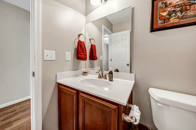 bathroom with vanity, hardwood / wood-style flooring, and toilet