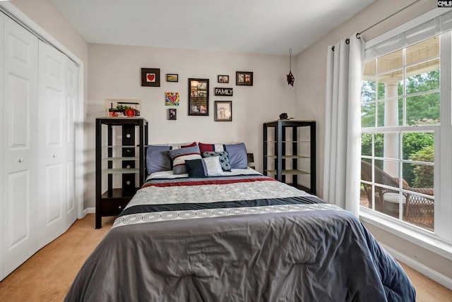 bedroom featuring light colored carpet and a closet