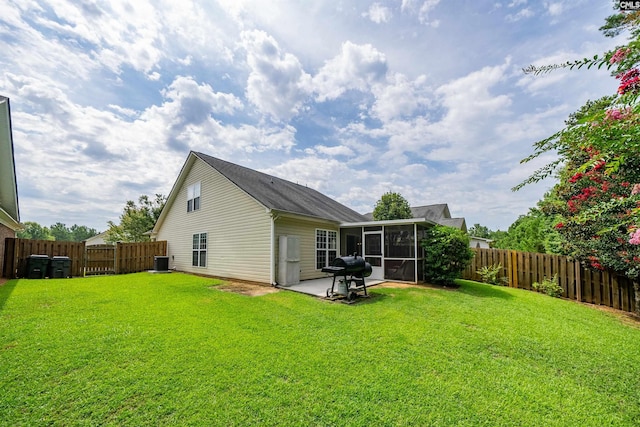 back of property featuring a patio, a sunroom, central AC, and a lawn