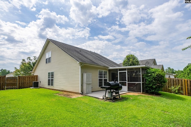 rear view of property featuring a patio, central air condition unit, a sunroom, and a yard