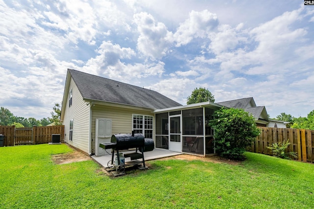 rear view of property featuring a sunroom, a yard, and a patio area