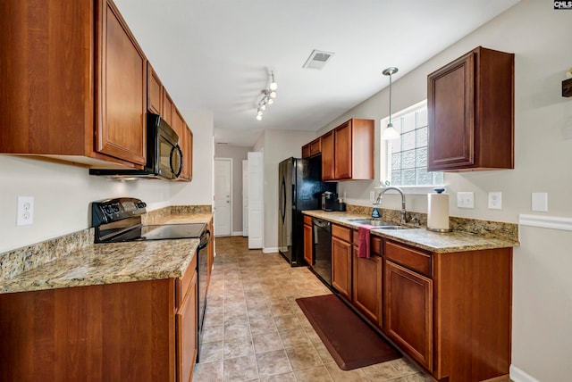 kitchen with black appliances, pendant lighting, rail lighting, sink, and light stone counters