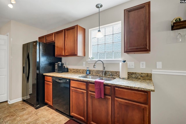 kitchen with black dishwasher, sink, pendant lighting, light stone counters, and light tile patterned floors