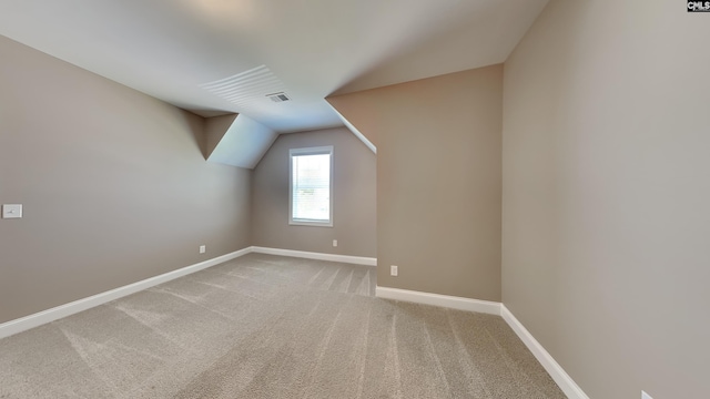 additional living space with vaulted ceiling and carpet flooring