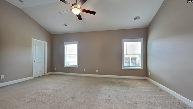 carpeted empty room with ceiling fan and high vaulted ceiling