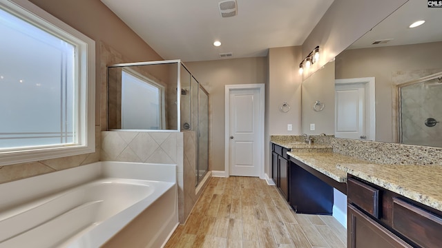 bathroom with vanity, hardwood / wood-style floors, and independent shower and bath