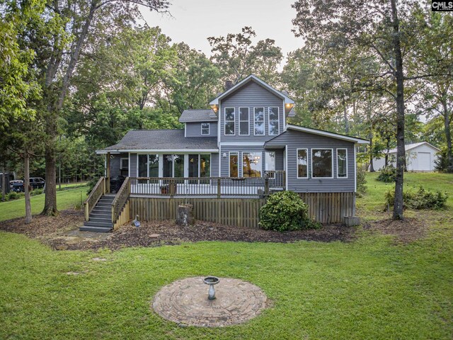 rear view of property with an outbuilding, a deck, and a lawn