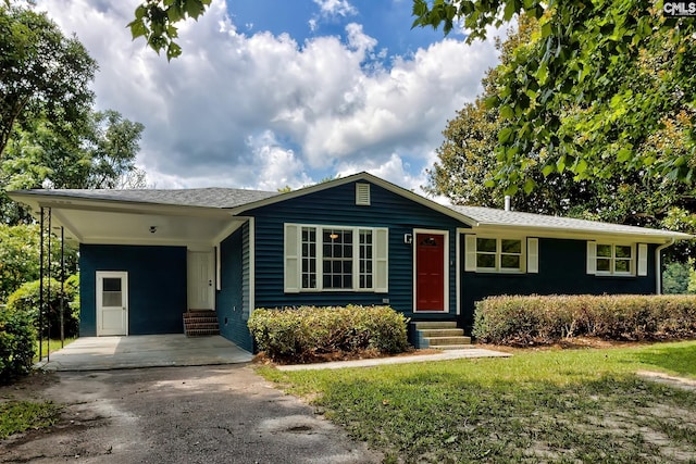 ranch-style home with a carport and a front lawn