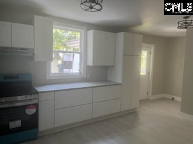 kitchen with white cabinetry, light hardwood / wood-style flooring, and electric range