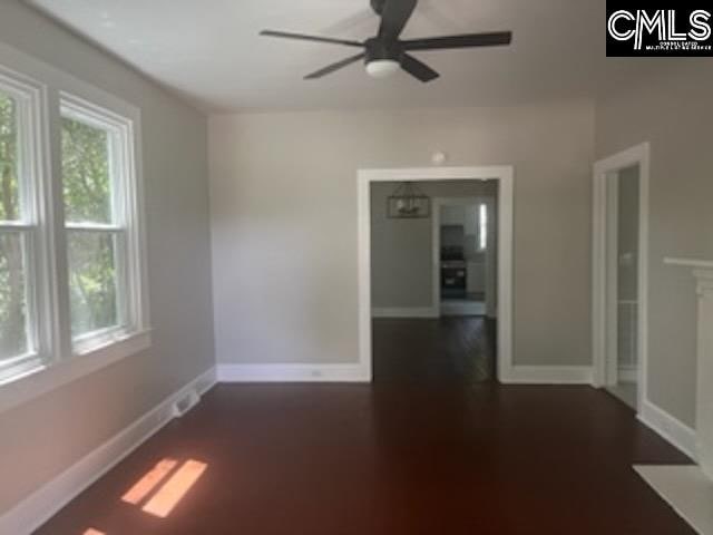 spare room featuring ceiling fan and dark hardwood / wood-style flooring