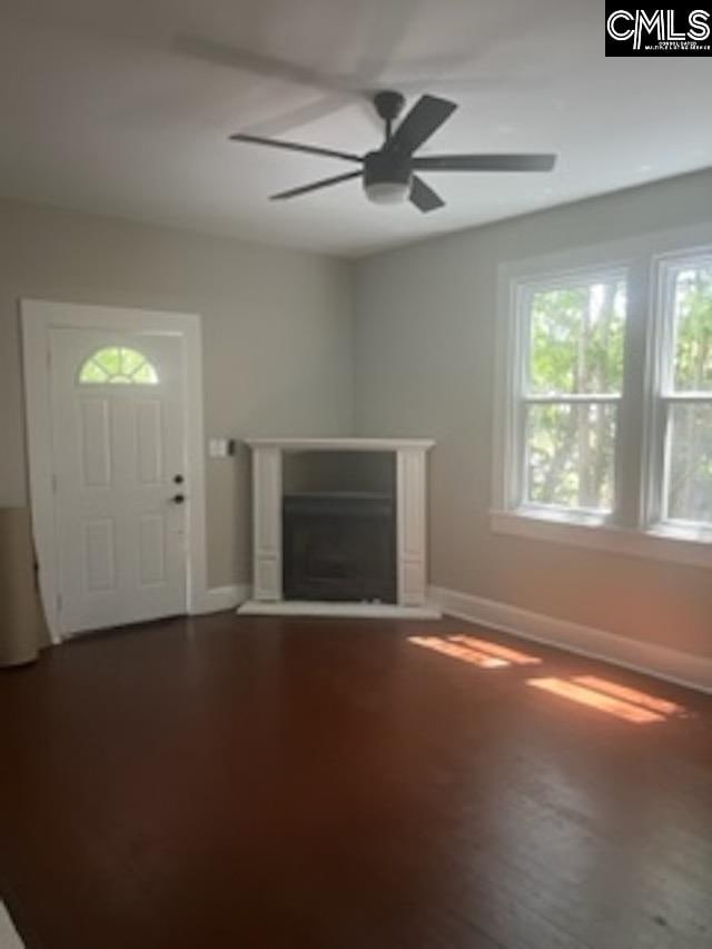 unfurnished living room featuring hardwood / wood-style floors and ceiling fan