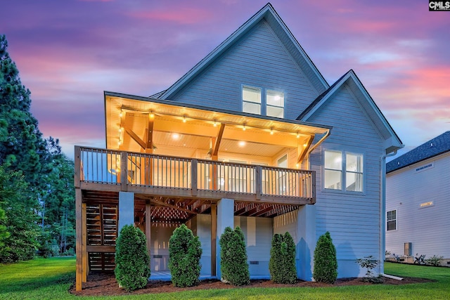 rear view of house featuring a deck, stairway, and a lawn