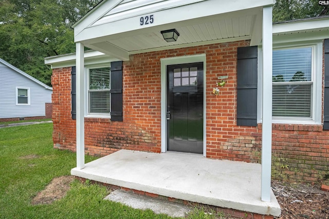 property entrance featuring a lawn