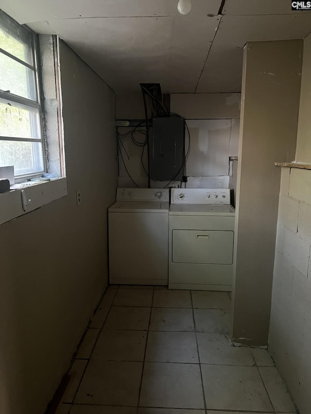 laundry area with washing machine and dryer and light tile patterned floors