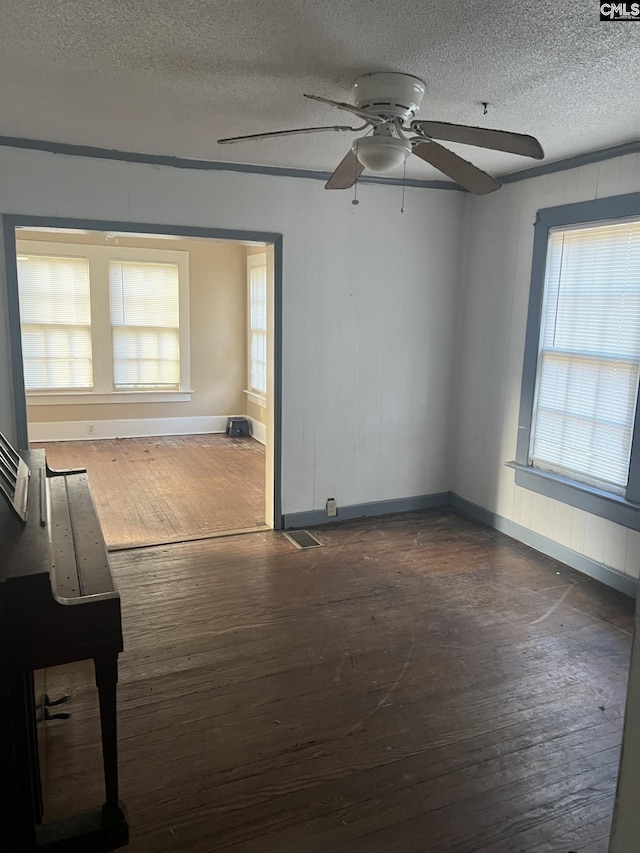 empty room with wood-type flooring, a textured ceiling, and ceiling fan