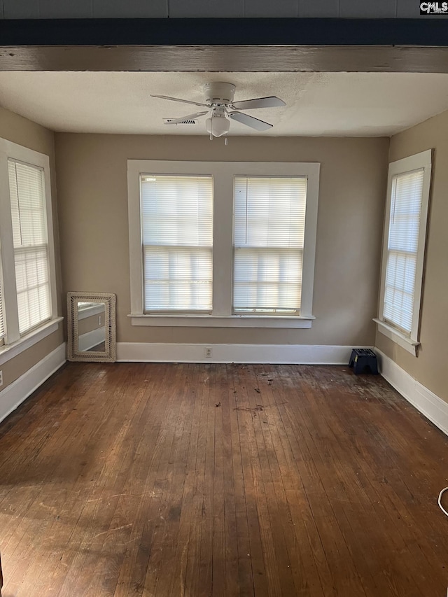 unfurnished room featuring dark wood-type flooring, ceiling fan, and a wealth of natural light